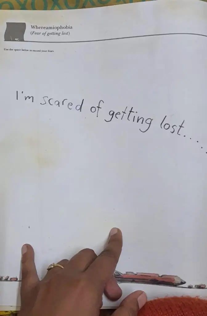 A picture of a page from a book. In the middle, it says "I'm scared of getting lost". At the bottom, you can see my hand on the page
